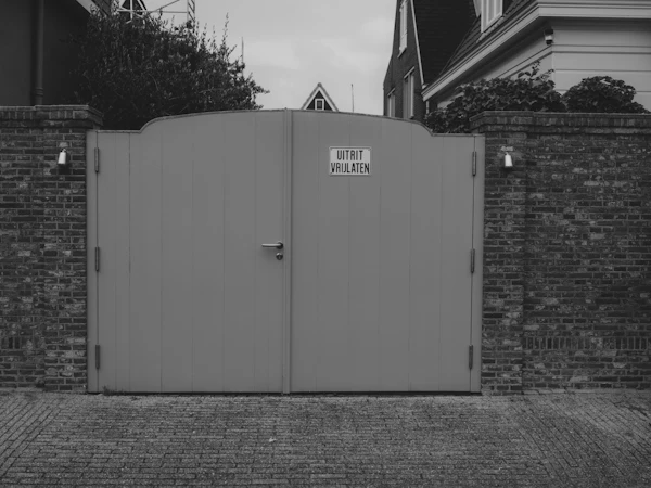 Steel driveway gate set in a brick wall
